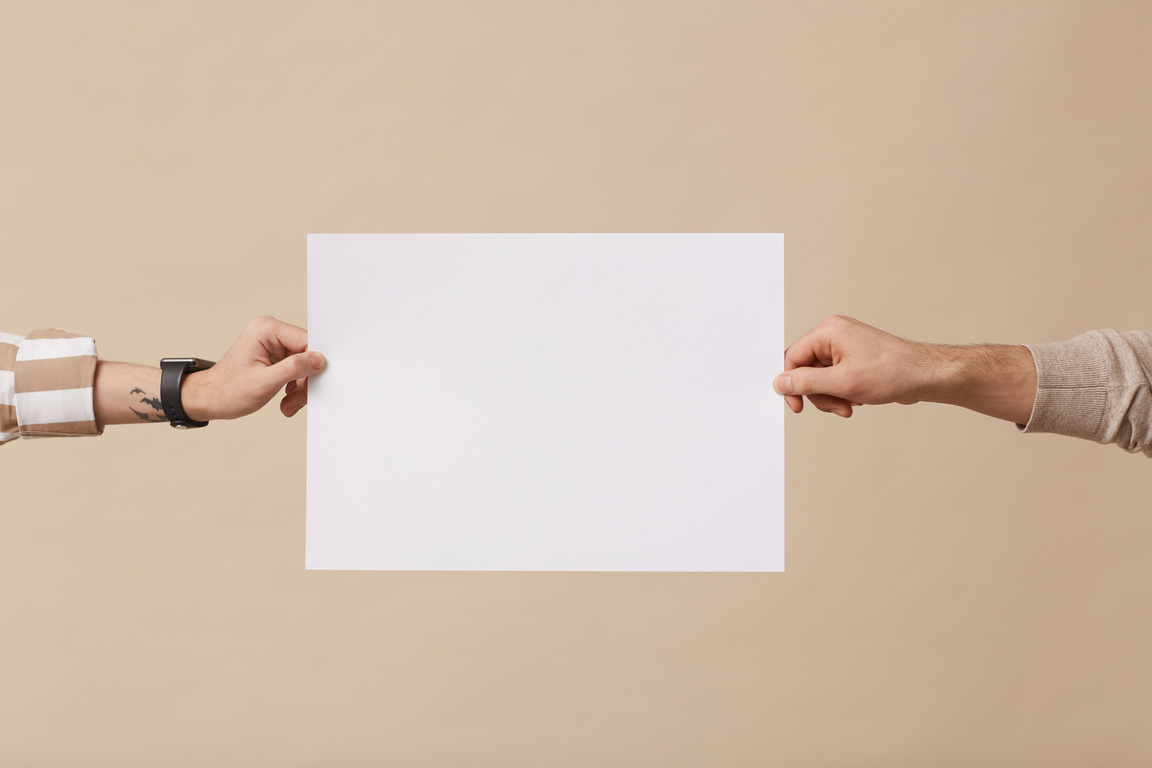 Two Hands Holding a Blank Paper on Beige Background